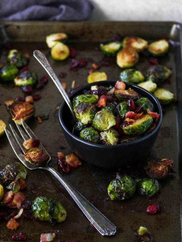 Brussels Sprouts with Bacon and Cranberries on a sheet pan and in a black bowl - Food Styling